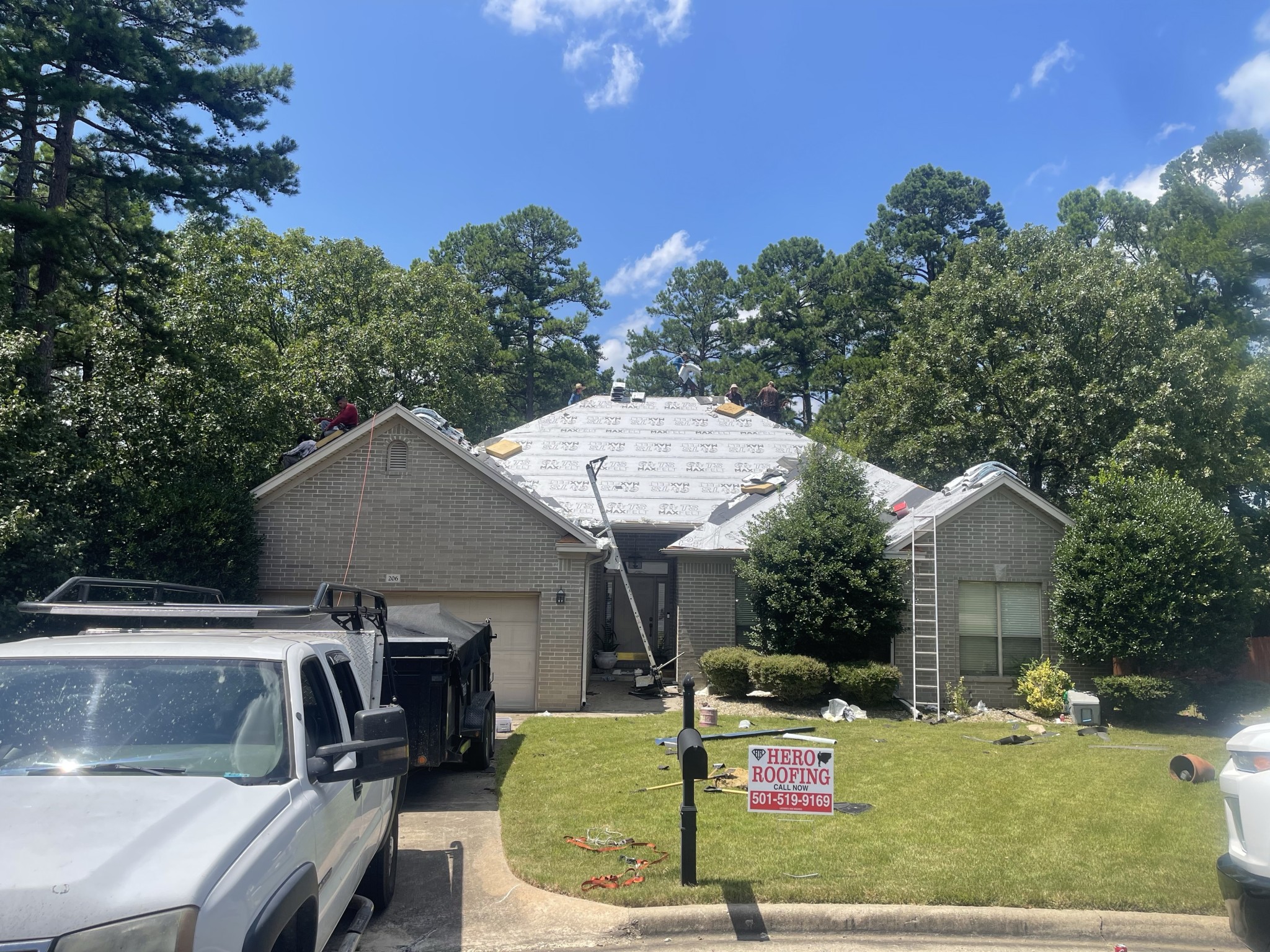 Hero Roofing crew on the roof with underlayment laid down during a roof replacement on a brick home in Central Arkansas